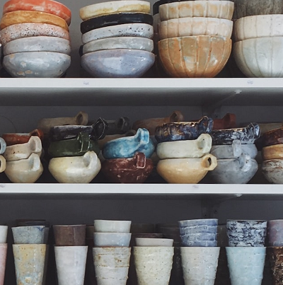 shelves-covered-with-various-handmade-pottery-displaying-a-wide-variety-of-glazed-finishes-and-colors