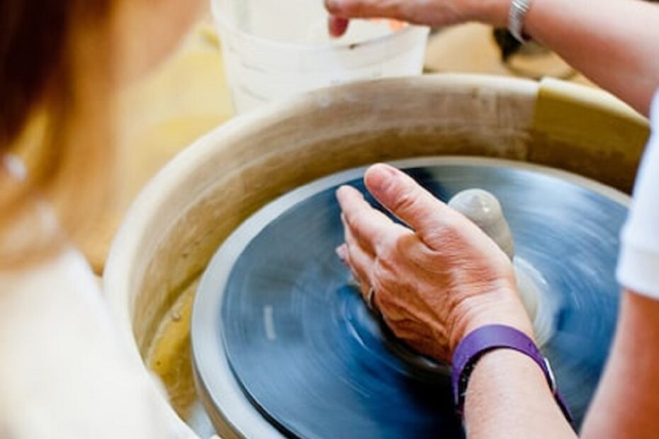 female-instructor-at-a-potters-wheel-giving-a-demonstration-first-pottery-class