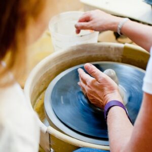 ceramics-instructor-giving-beginning-pottery-demonstration-on-pottery-wheel