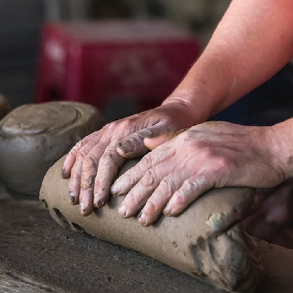 a-potter-using-the-process-of-clay-wedging-on-a-mound-of-recycled-clay